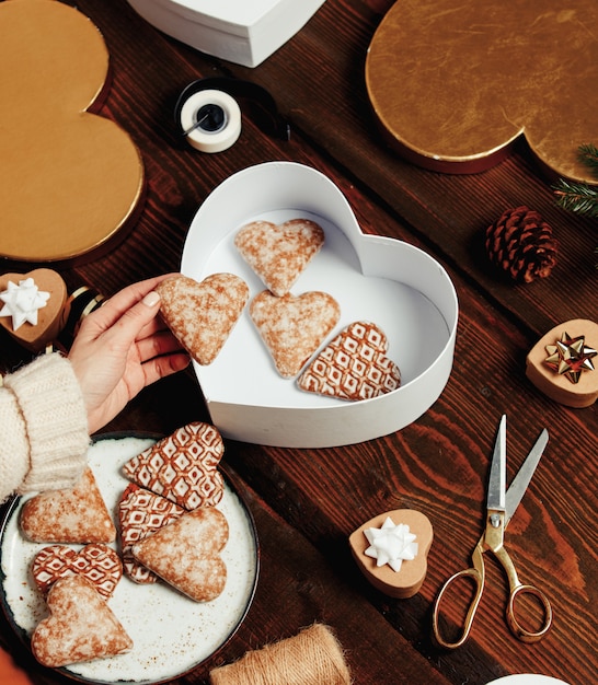 Femme met des biscuits dans une boîte avec des cadeaux