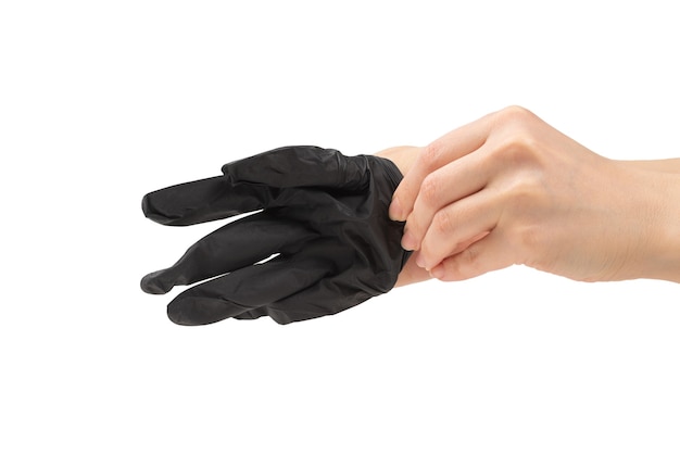 La femme met des gants en caoutchouc noir. Isolé sur blanc.