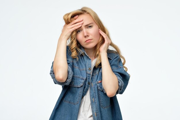 La femme met des mains sur la tête ayant une douleur terrible