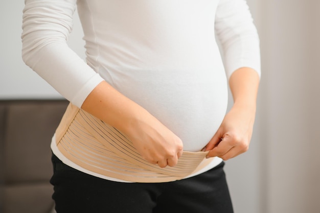 La femme met un pansement pour les femmes enceintes. Fermer.