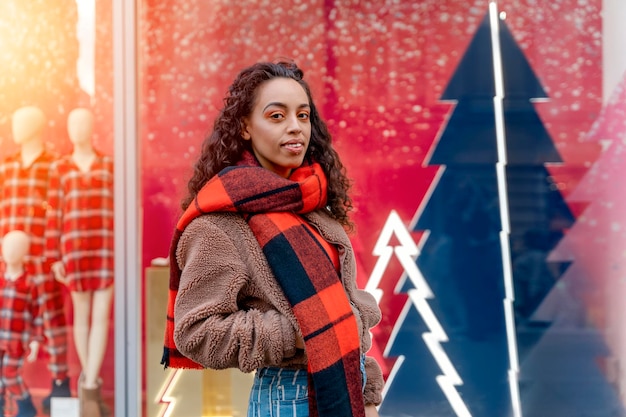 Photo femme métisse africaine marchant dans la ville de célébration avant noël et à la recherche de cadeaux