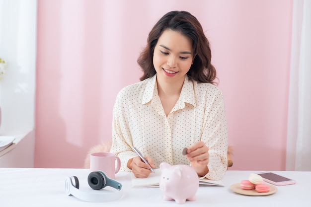 Femme mettant la pièce dans la tirelire. économiser de l'argent, budget, investissement, concept de finance