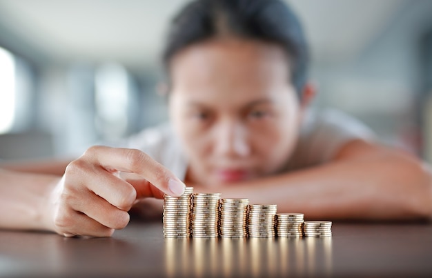 Femme mettre des pièces de monnaie pour empiler des pièces de monnaie.