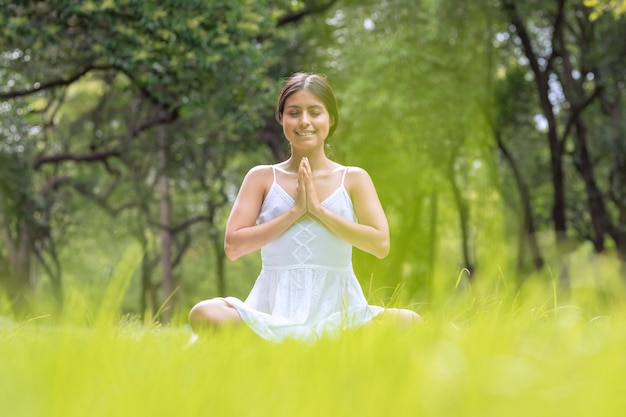 Femme mexicaine en position de fleur de lotus méditant dans le parc