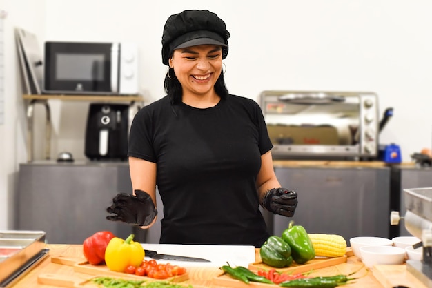 Femme mexicaine riant pendant la cuisson des tacos dans la cuisine