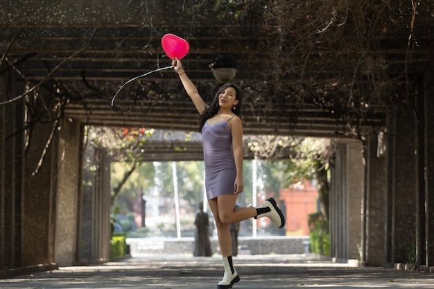 Femme mexicaine tenant une expression heureuse de ballon rouge