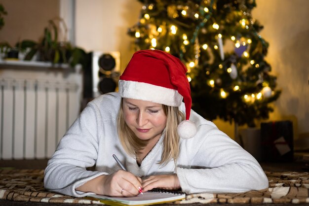 Une femme mignonne écrit une lettre au Père Noël