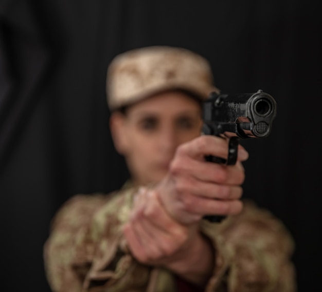 Femme militaire avec une arme à feu à la main visant à la caméra