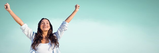 Femme millénaire avec les bras en l'air sur fond vert clair