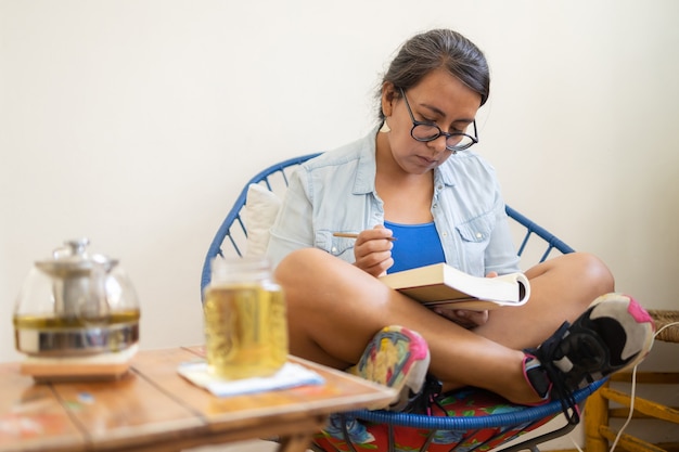 Photo femme millénaire tatouée mexicaine lisant un livre