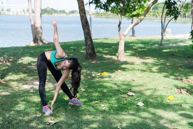 Une femme mince asiatique s'échauffe avant de faire de l'exercice pour une fille mince pour la vieThaïlande Étirement du corps avant de faire du jogging