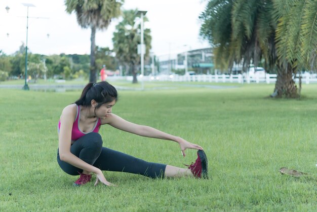 Une femme mince asiatique s'échauffe avant de s'entraîner dans un exercice matinal pour une fille mince pour la vie