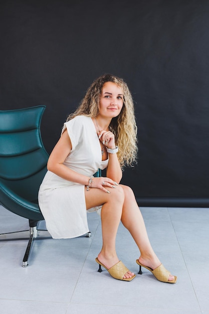 Une femme mince vêtue d'une robe d'été blanche et de sandales à talons