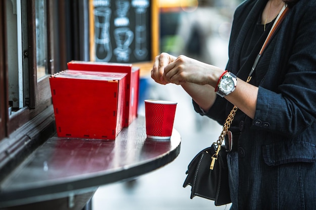 Femme a mis du sucre dans une tasse de café en papier rouge