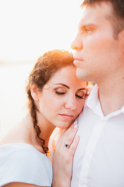 La femme a mis sa tête et sa main sur l'épaule de l'homme regardant au loin en gros plan