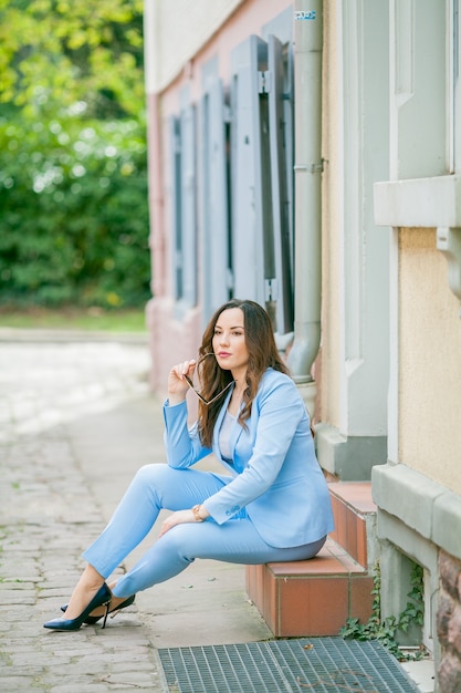 femme à la mode assise à l'extérieur