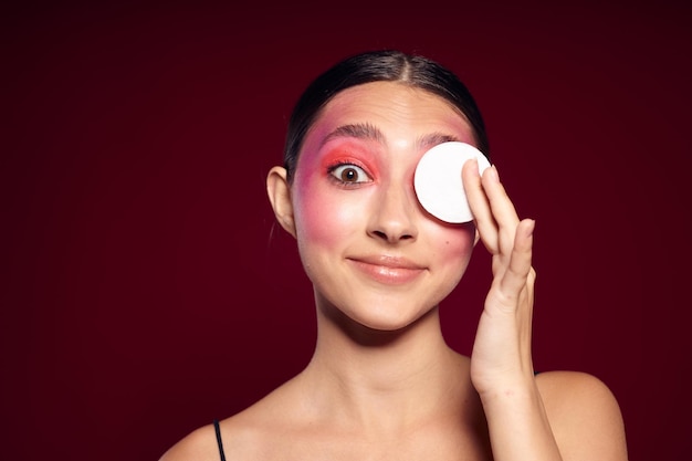 Femme à la mode coton tampons cuir propre maquillage lumineux posant vue recadrée inchangée