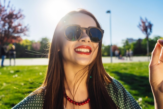 Femme de mode dans des verres à l'extérieur. Fille souriante de glamour d'été