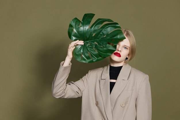 Photo femme à la mode lèvres rouges feuilles de palmier charme mode fond isolé photo de haute qualité
