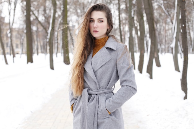 Femme à la mode qui marche en ville en manteau chaud