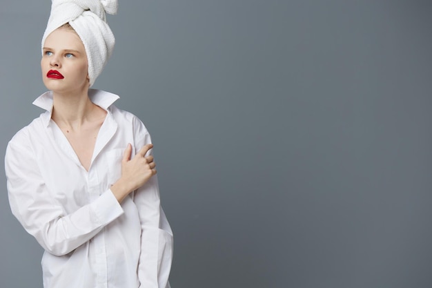 Femme à la mode avec une serviette sur la tête dans une chemise blanche fond isolé