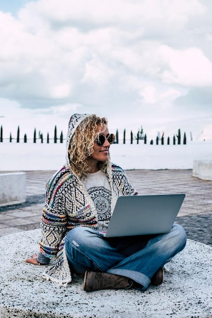 La femme moderne voyage en plein air avec la technologie et la connexion à Internet, un ordinateur portable et l'itinérance, les gens et le concept de nomade numérique, le style de vie, la vie professionnelle intelligente et le bureau.