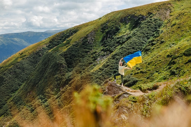 Une femme sur les montagnes avec un drapeau ukrainien