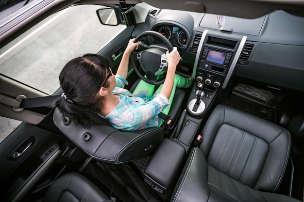 La femme monte sur la voiture à grande vitesse.