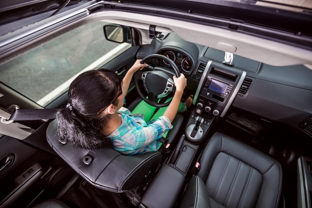 La femme monte sur la voiture à grande vitesse.