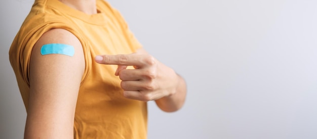 Femme montrant un bandage après avoir reçu le vaccin covid 19. Vaccination, immunité collective, effet secondaire, dose de rappel, passeport vaccinal et pandémie de coronavirus