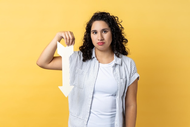 Femme montrant une flèche blanche pointant vers le bas exprimant le concept de déclassement d'émotions tristes