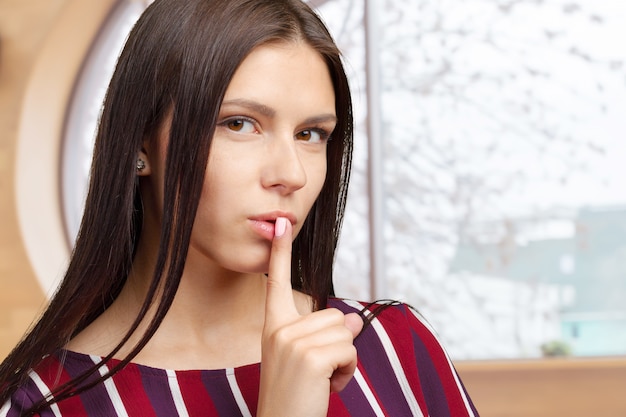 Femme montrant un geste de silence