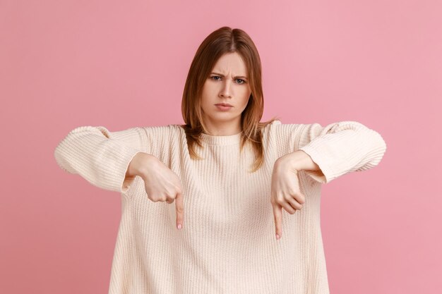 Femme montrant la place à côté d'elle donnant l'ordre avec une expression autoritaire stricte