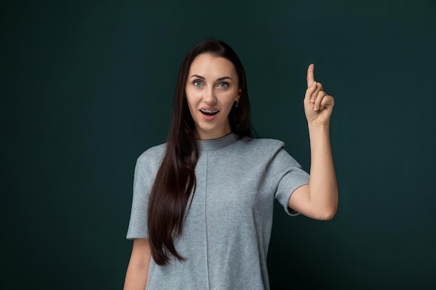 Une femme montrant quelque chose avec son doigt.