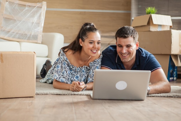 Femme montrant à son mari la nouvelle télévision qu'ils vont acheter pour leur nouvelle maison