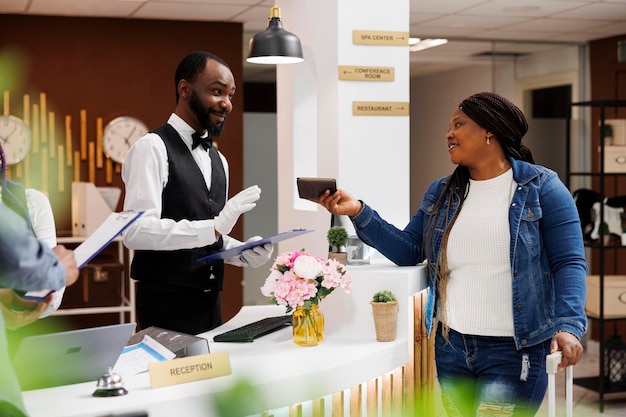 Femme montrant son passeport à l'enregistrement de l'hôtel