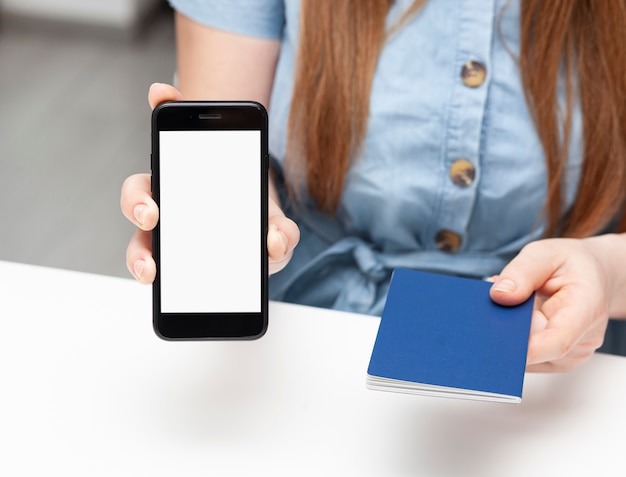 Photo femme montrant le téléphone avec écran vide et donne passoprt. conception de maquette