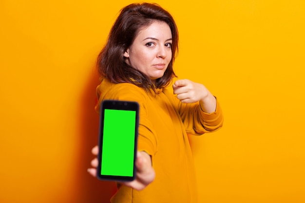 Femme montrant un téléphone portable avec écran vert vertical