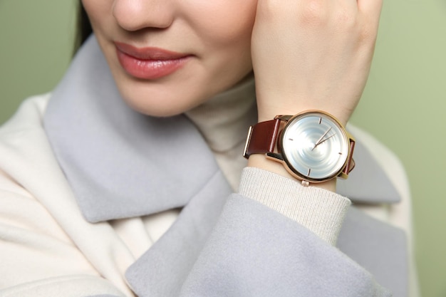 Femme avec montre-bracelet de luxe sur fond vert libre