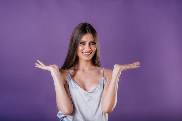 femme montre des émotions et des sourires sur le mur violet