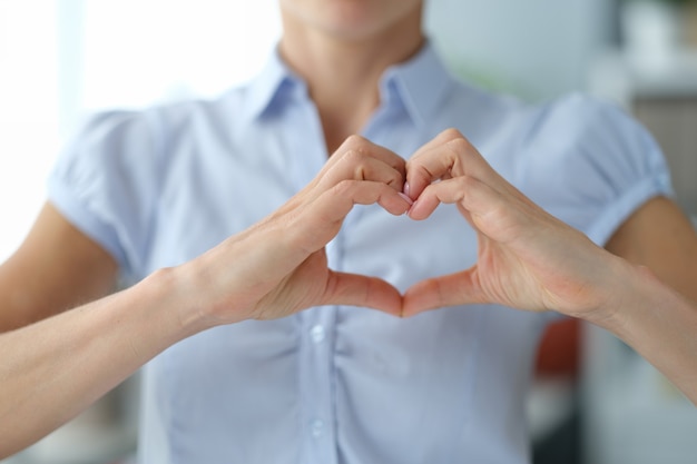 La femme montre le geste de la main du coeur de l'amour femme volontaire montre la sympathie et le concept de soins