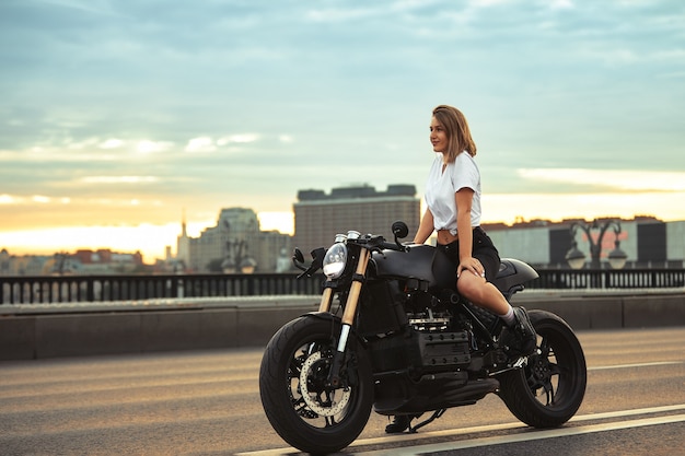 Femme de motard assis sur un portrait de mode de vie en plein air moto personnalisé vintage