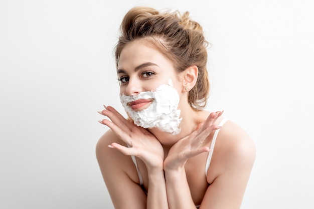 Femme avec de la mousse à raser sur son visage