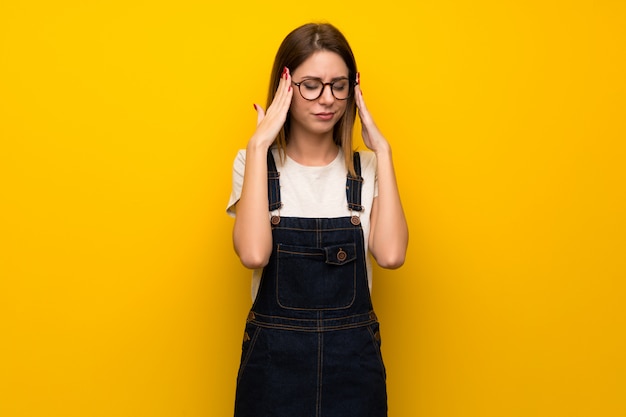 Femme, mur jaune, mal tête