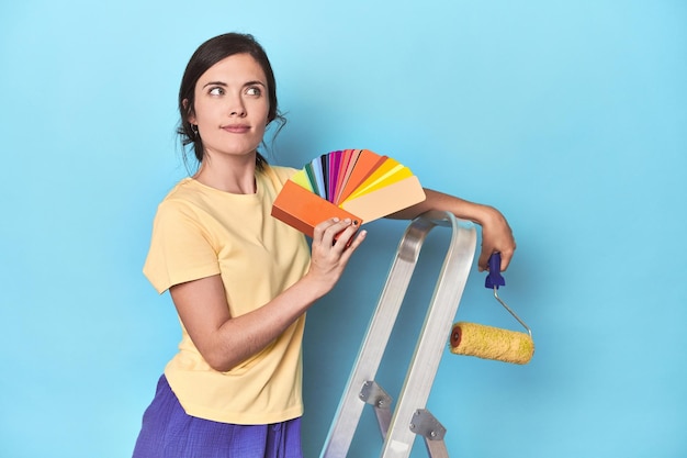 Femme avec mur de peinture de palette de couleurs sur échelle