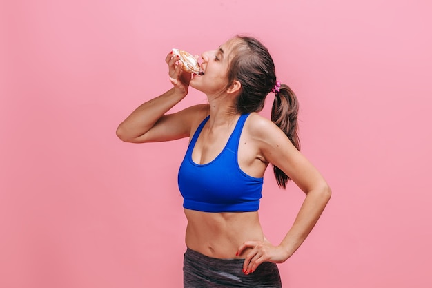 femme, sur, mur rose, manger, gâteau