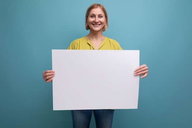 Femme mûre blonde souriante tenant un tableau de notes avec mocap