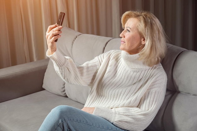 Une femme mûre communique par appel vidéo à l'aide d'un smartphone