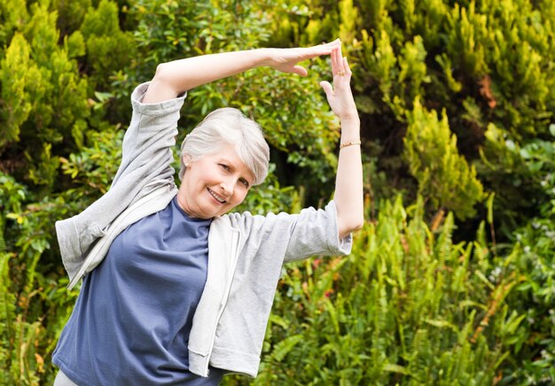 Femme mûre faisant ses étirements dans le jardin