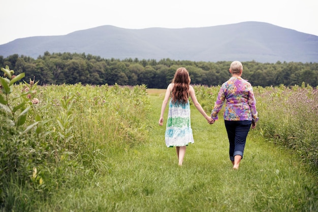 Une femme mûre et une jeune fille dans une prairie de fleurs sauvages